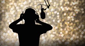 Image depicting a silhouette of a person with headphones on and the outline of a microphone.