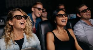 Group of people laughing in a dark movie theatre