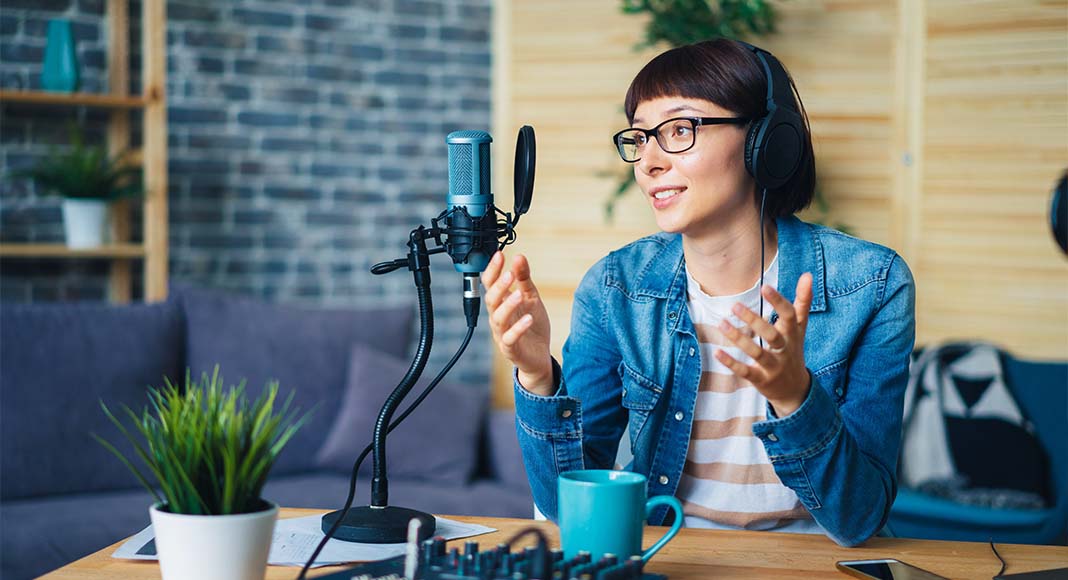 Happy female radio host broadcasting in studio