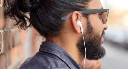 man with ear buds listening to jingles of the 2000s