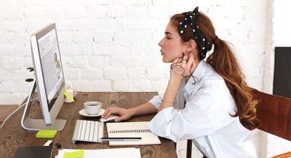 woman sitting at desk looking pensive