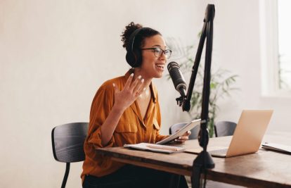 Professional female podcaster making a podcast from home studio. Woman working from home recording a podcast.