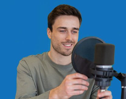 A man adjusts a pop filter on his microphone.