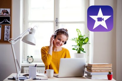 A woman works on her laptop in her office with a purple iMovie logo over her right shoulder.