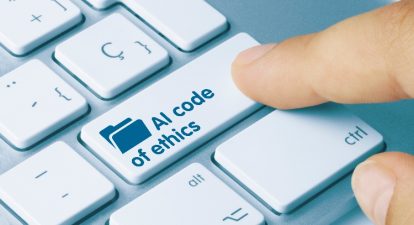 A finger hovering over a computer keyboard with one key that says AI code of ethics.