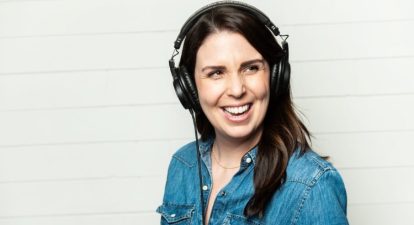 A guide to the female voice represented by a woman with black hair wearing headphones and smiling towards the camera.