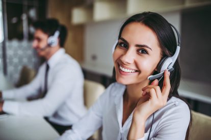 Call center workers in headphones are working at modern office.