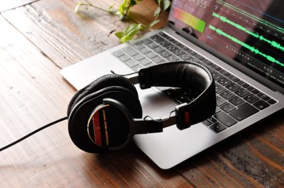 Headphones resting on a laptop on an office desk