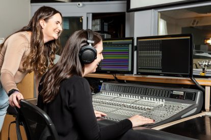 Two women at an audio recording console