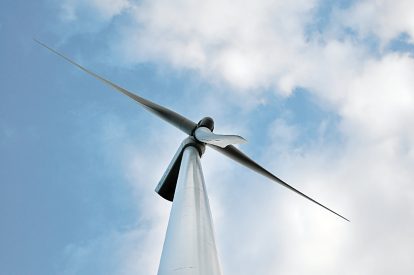 A photo of a wind turbine in front of a cloudy sky.