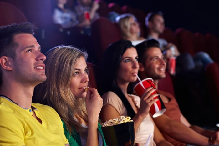 A group of people watching a movie and being entertained.