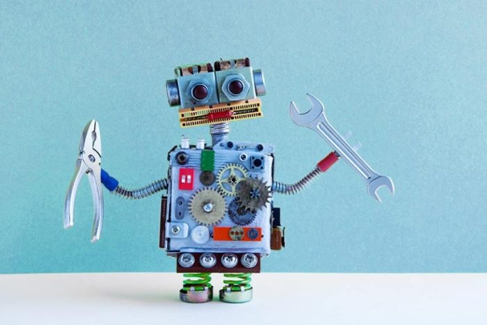 A talking robot toy holding pliers and a wrench.