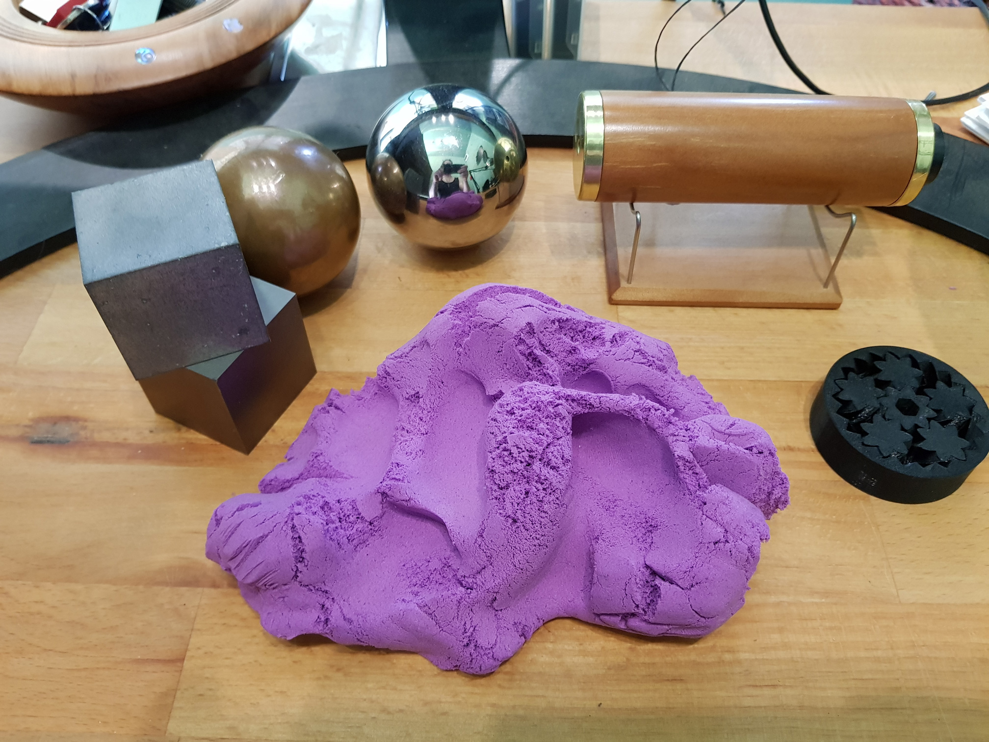 On a desk sits various objects, including putty, blocks and balls, and various other objects to fidget with.