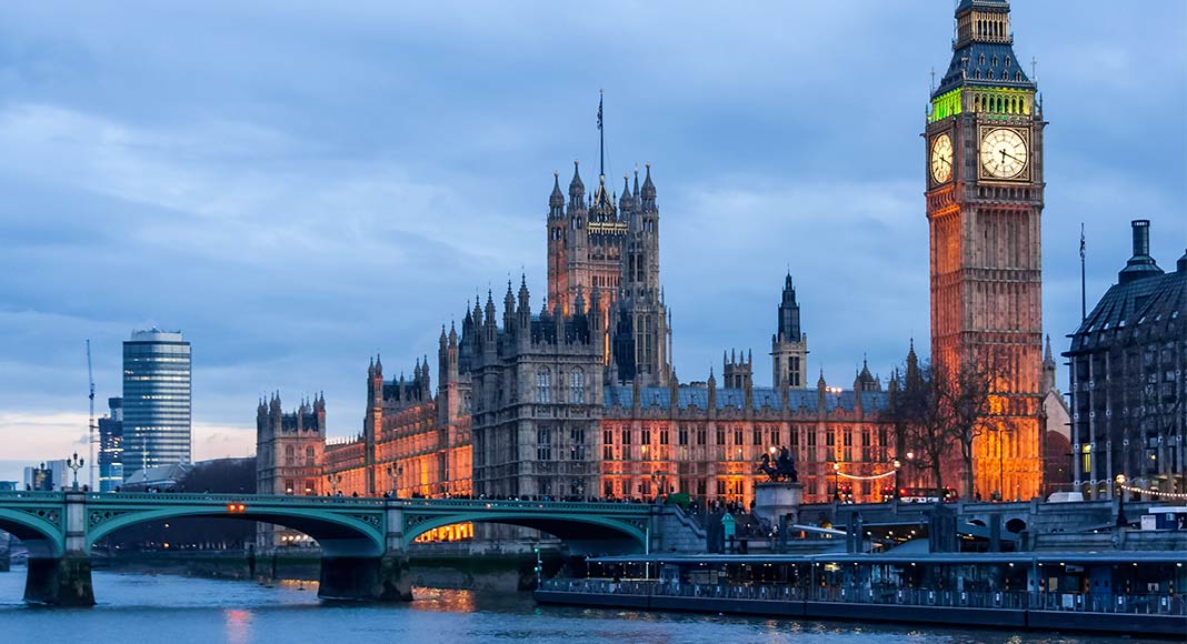 A photo shows the Palace of Westminster (in the UK) at dusk