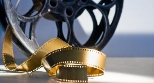 a golden film reel and unraveling film