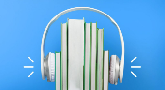 A stack of books being pressed together by a pair of headphones.