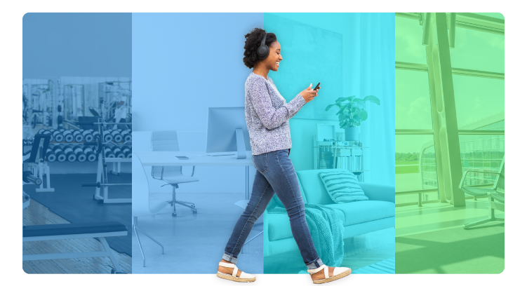 Woman walking through multicolored room, listening to audio on phone
